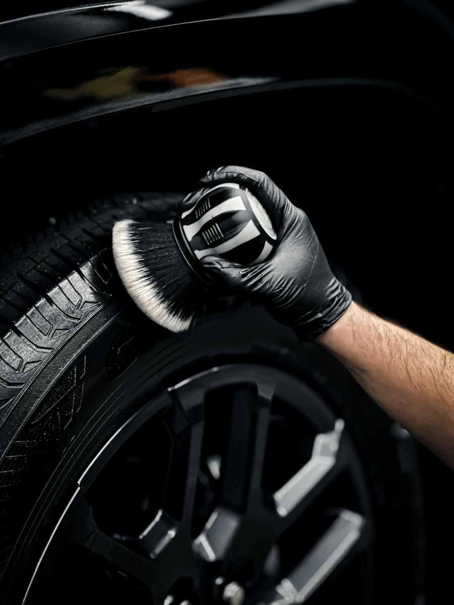 Detailer cleaning a tire with a soft brush